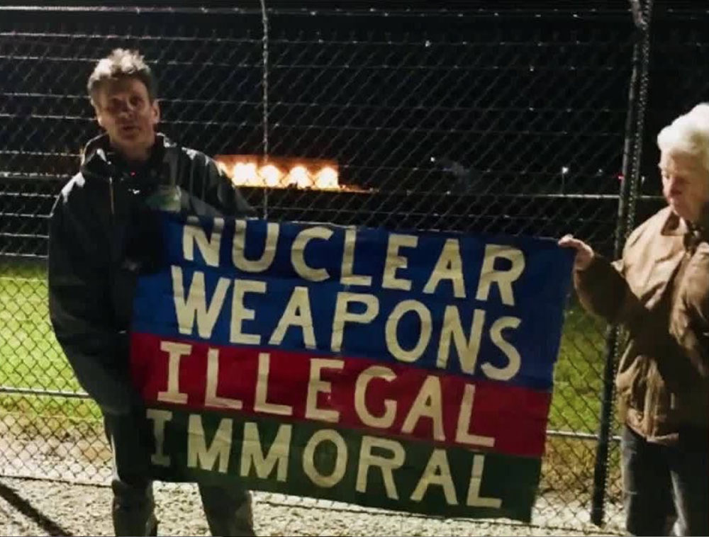 Carmen Trotta, left, and Elizabeth McAlister hold a sign while entering the Kings Bay Naval Submarine Base in St. Marys, Georgia. (RNS photo/Courtesy of Kings Bay Plowshares 7)