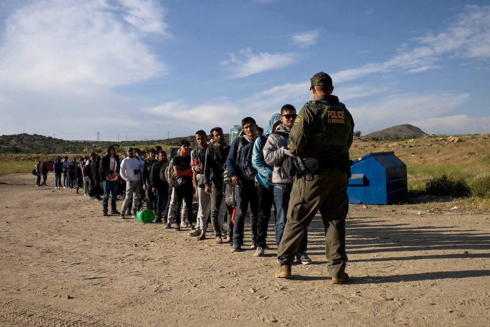Migrants from Jordan, China, Egypt and Colombia surrender to a Border Patrol agent after crossing into the U.S. from Mexico in Jacumba Hot Springs, Calif., May 15, 2024. (OSV News/Reuters/Adrees Latif)