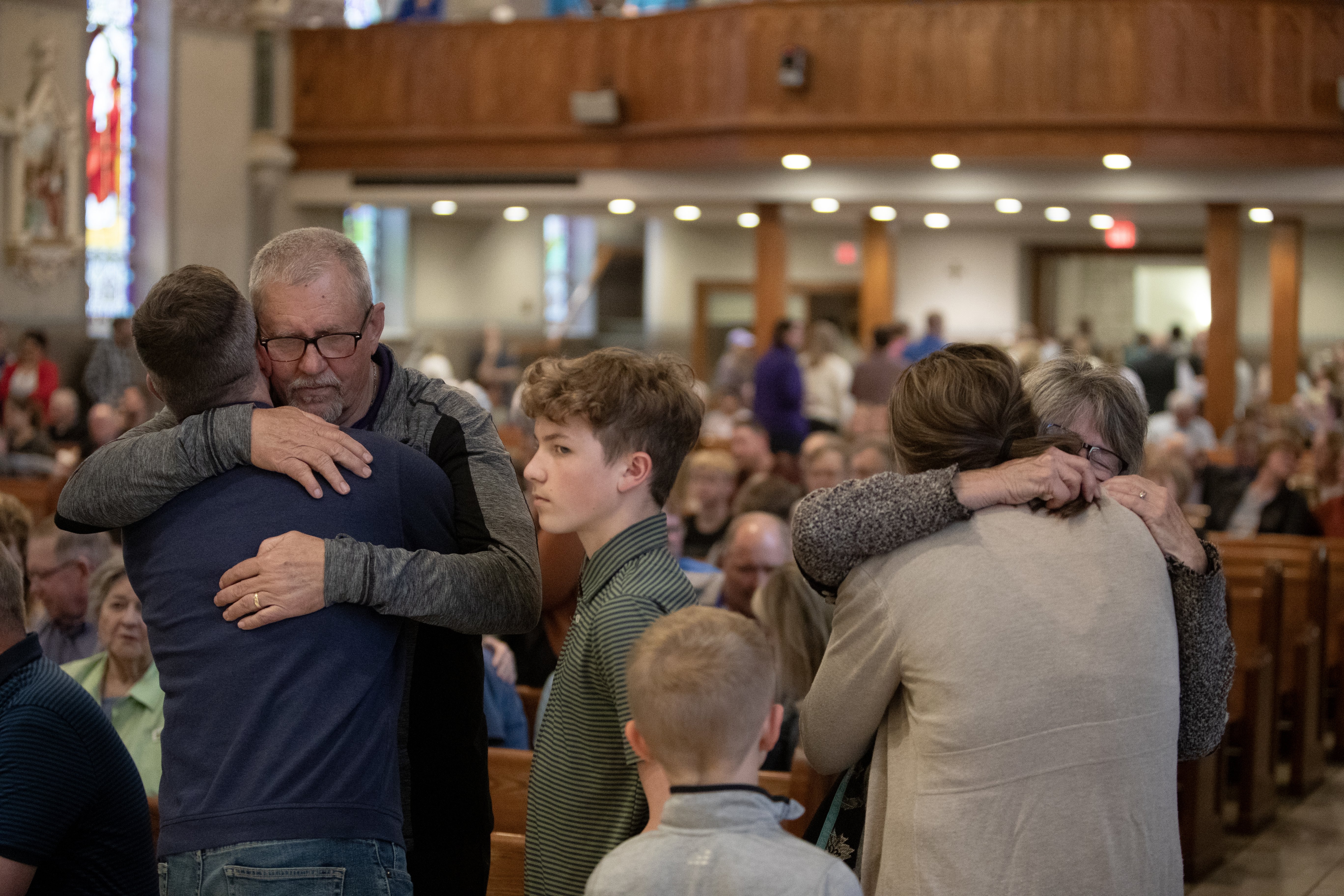 Parishioners of Sts. Peter and Paul Parish in Seneca, Kansas, embrace before a special Mass concelebrated by Archbishop Joseph F. Naumann of Kansas City April 3, 2025. Earlier that day the parish's pastor, Father Raj "Arul" Carasala, 57, was fatally shot in front of the parish rectory. (OSV News photo/Jay Soldner, The Leaven)