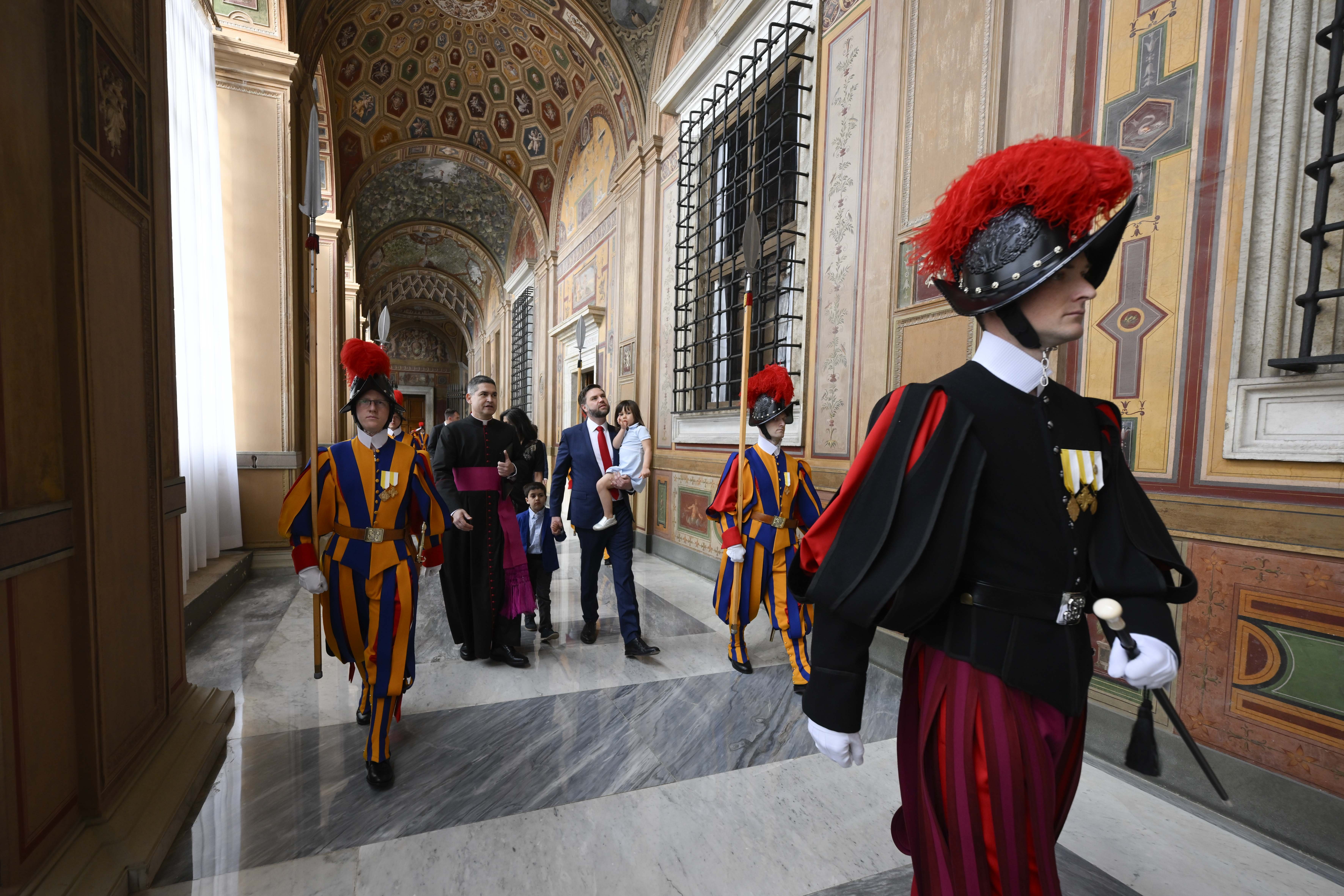 U.S. Vice President JD Vance, carrying his daughter, and the rest of his family are escorted to his meeting with Cardinal Pietro Parolin, Vatican secretary of state, in the Apostolic Palace at the Vatican April 19, 2025.