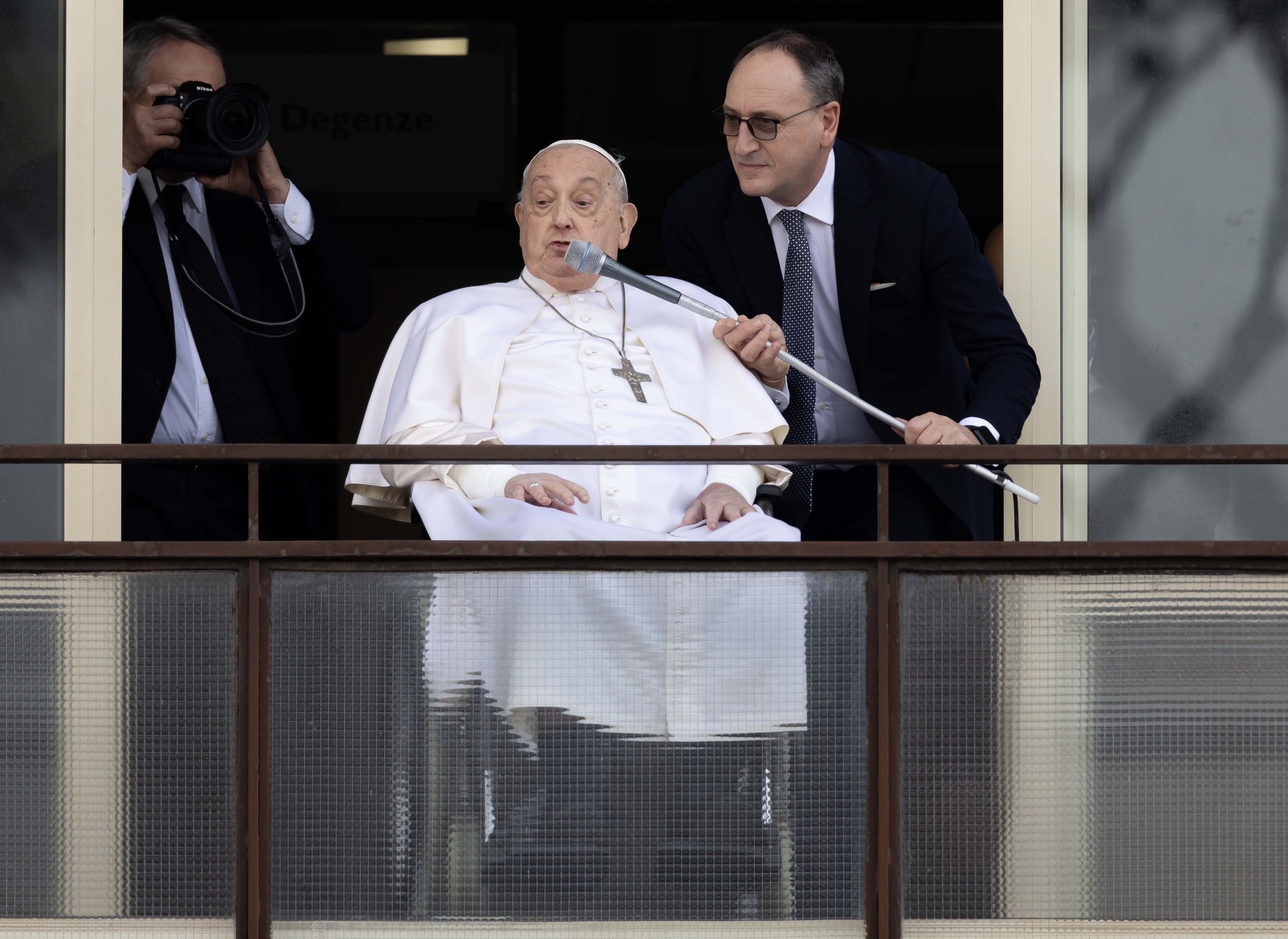 Massimiliano Strappetti, the nurse who is Pope Francis' primary medical caregiver at the Vatican, adjusts a microphone for the pope as he greets a crowd of well-wishers at Rome's Gemelli hospital before returning to the Vatican March 23, 2025. Pope Francis, formerly Argentine Cardinal Jorge Mario Bergoglio, died April 21 at age 88. (CNS photo/Pablo Esparza)