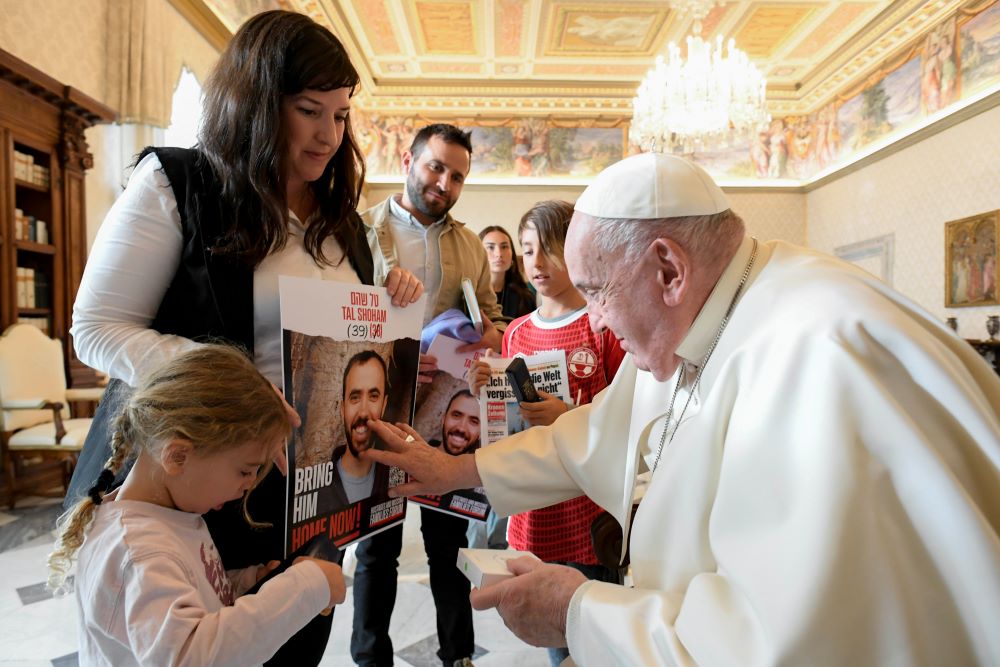 Accompanied by her children, Yahel and Naveh, Adi Shoham holds a poster of her husband, Tal Shoham, 39, during a meeting with Pope Francis at the Vatican Nov. 14, 2024. The Shoham family had been among those taken hostage by Palestinian militants Oct. 7, 2023. (CNS/Vatican Media)