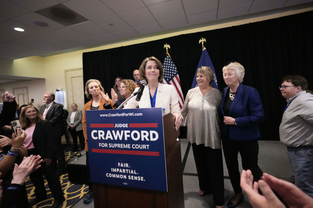 Wisconsin Supreme Court candidate Susan Crawford, surrounded by smiling staffers and clapping voters, speaks during her election night party after winning the election Tuesday, April 1, 2025, in Madison, Wis. (AP Photo/Kayla Wolf)
