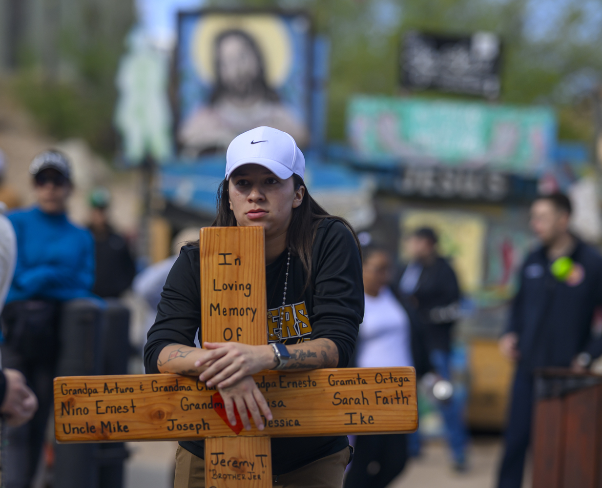 Maria Sandoval leans on a handmade cross bearing the names of loved ones passed as she waits in line to visit El Santuario De Chimayo in Northern New Mexico on Good Friday, April 18, 2025. Chimayo, N.M. (AP Photo/Roberto E. Rosales)
