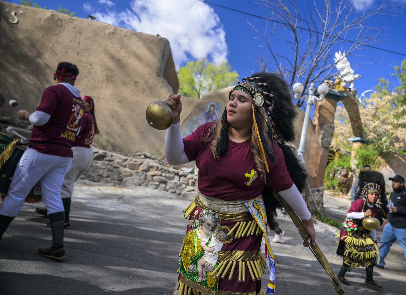 Josie Esquivel along with members of the Danza Señor San Jose dance group performs behind El Santuario De Chimayo in Northern New Mexico on Good Friday, April 18, 2025. Chimayo, N.M. (AP Photo/Roberto E. Rosales)