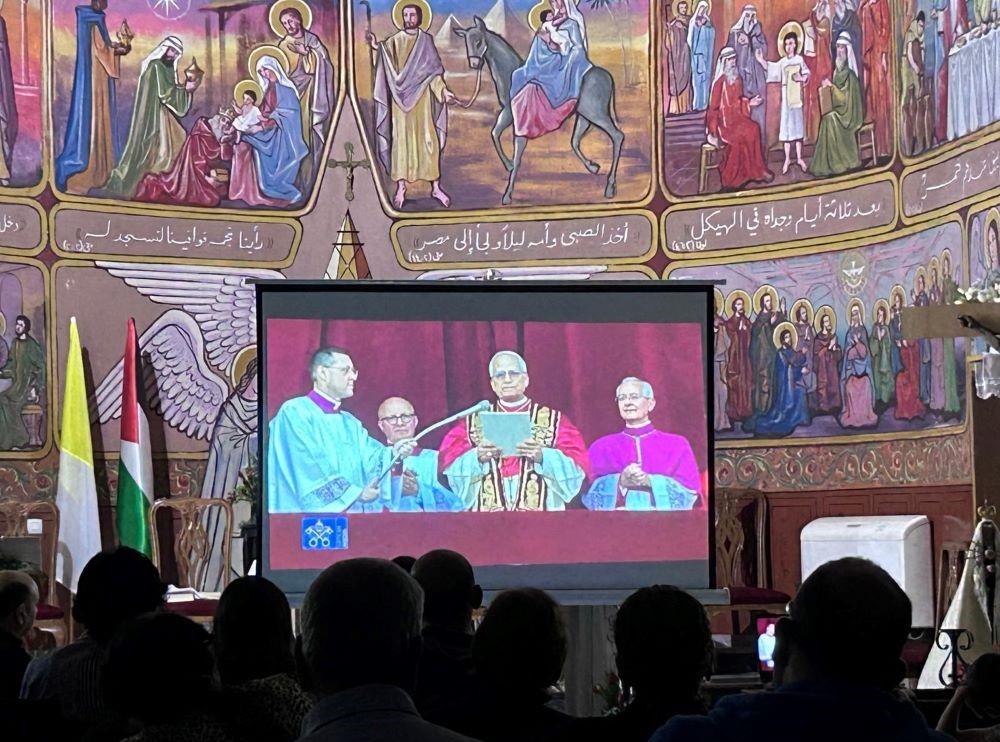 Catholics in Holy Family Parish in Gaza City watch the first appearance of Pope Leo XIV on a large screen.