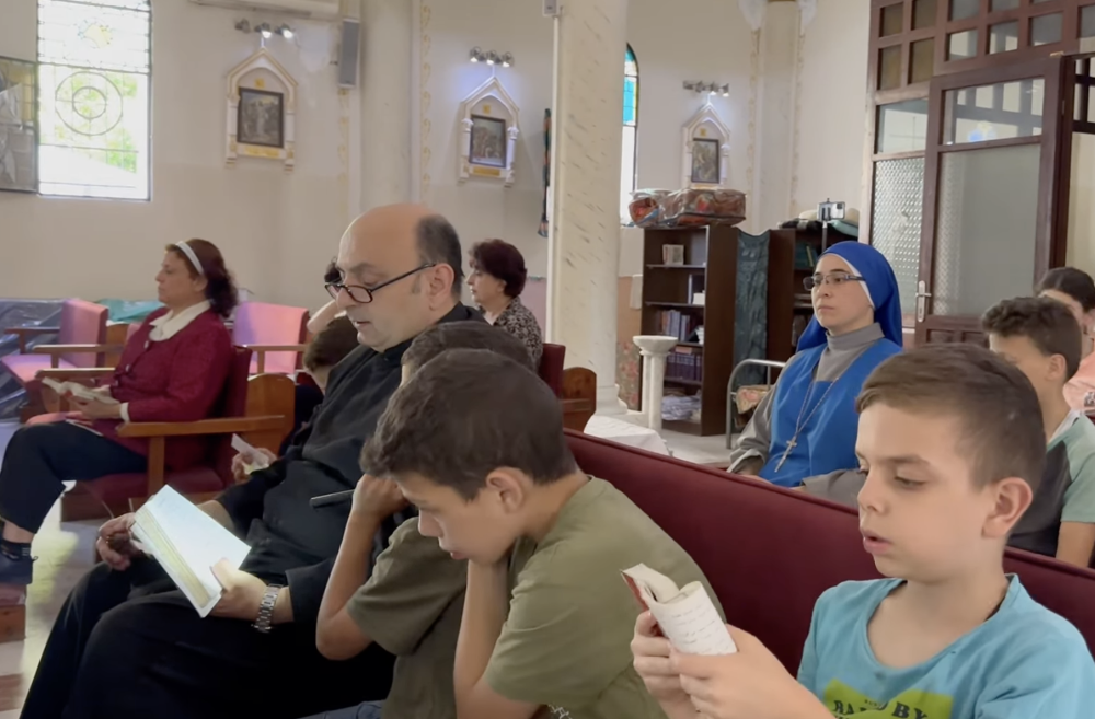 Fr. Gabriel Romanelli prays with children in Holy Family Parish in Gaza City in May 2025. From Oct. 7, 2023, until his death April 21, Pope Francis called the parish at the same time every night. (Courtesy of Gabriel Romanelli)