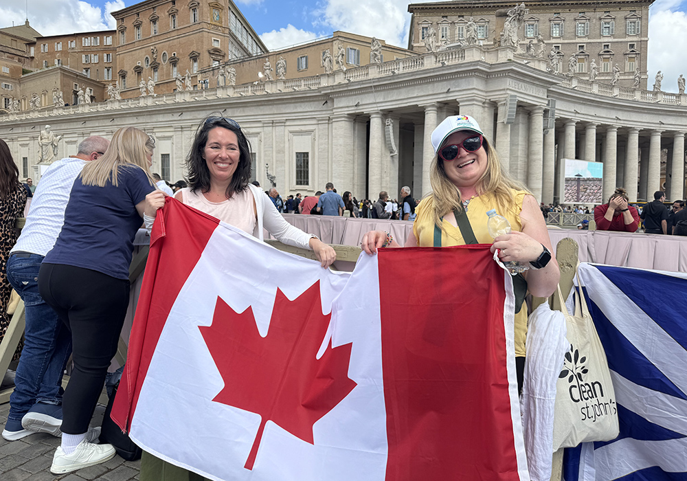 Elizabeth Whelan of Newfoundland, on right, holds a Canadian flag May 8 in St. Peter's Square.  (NCR photo/Rhina Guidos) 