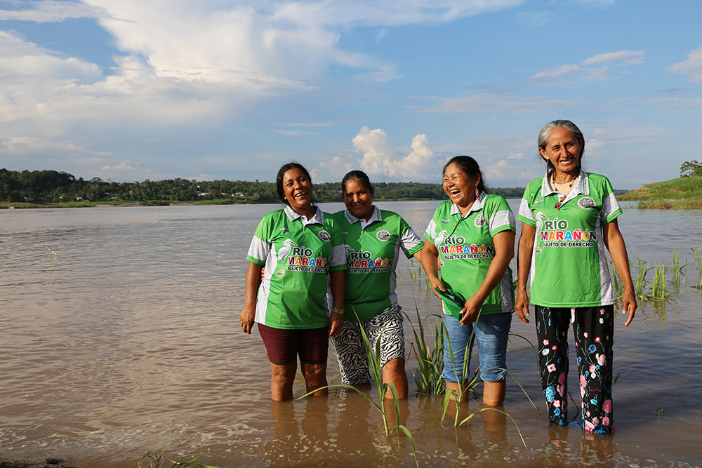 Leaders of Huaynakana Kamatahuara Kana stand in the Marañón River in Peru. Mari Luz Canaquiri is second from right. (Quisca Productions/Miguel Araoz)