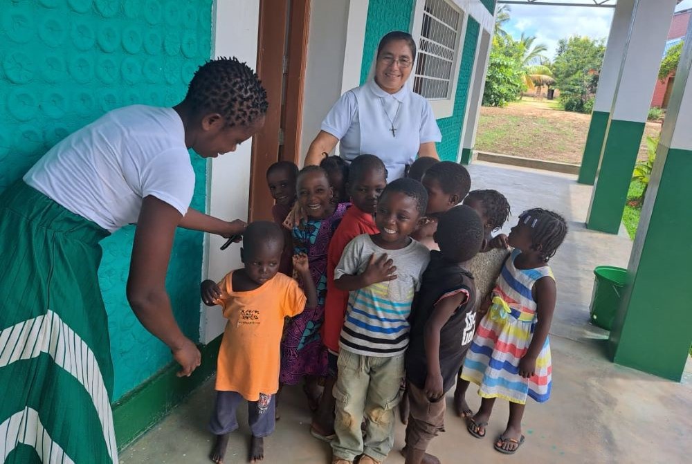 La hermana agustina Aurora Jacinto posa con unos niños frente a un aula construida con botellas de plástico. Las hermanas animan a la comunidad a recoger botellas de plástico para utilizarlas como material de construcción de aulas que resistan fenómenos meteorológicos extremos, como los ciclones. (Foto: Tawanda Karombo)