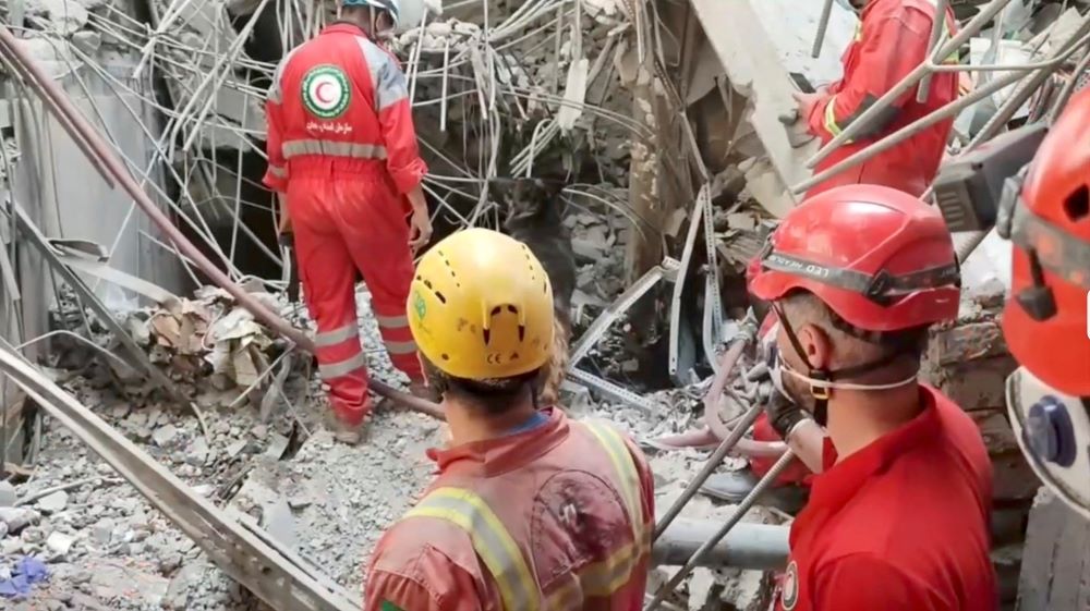 Members of the Iranian Red Crescent Society inspect a damaged building following an Israeli strike.