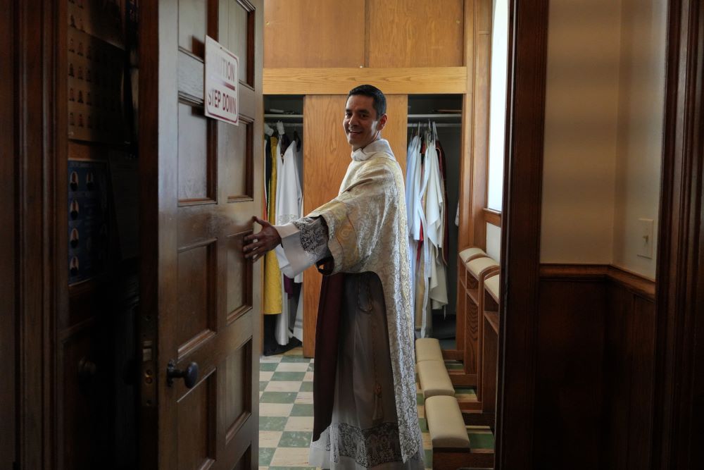 Alfredo Tuesta opens the door to the sacristy after a Mass at St. James Catholic Church, Falls Church, Va., on May 24. He was ordained as a priest June 7. (AP/Luis Andres Henao)