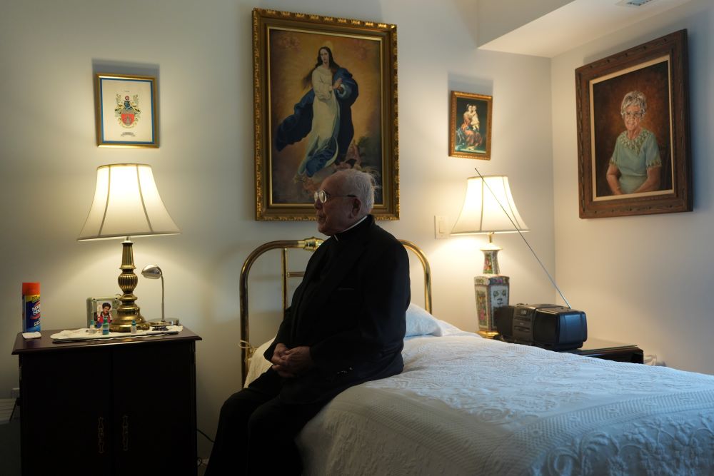 Fr. James Kelly sits in his apartment.