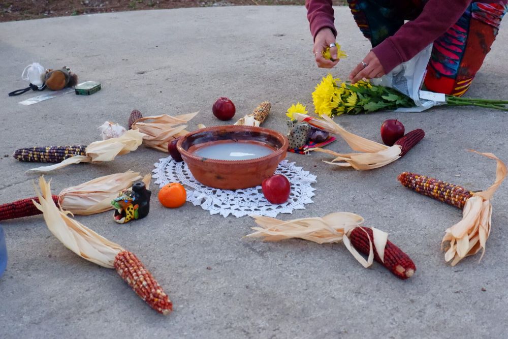 A community member prepares a temporary altar at the ceremony site in Brackenridge Park in San Antonio.