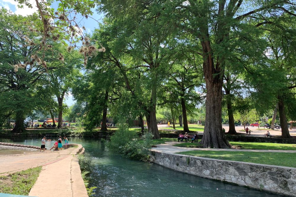 Visitors walk and rest along the winding San Antonio River in Brackenridge Park in San Antonio. 