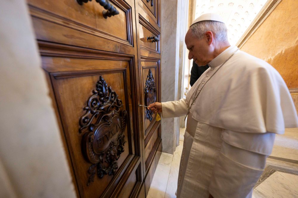 Pope Leo XIV opens the door to the papal apartment in the Apostolic Palace at the Vatican May 11. 