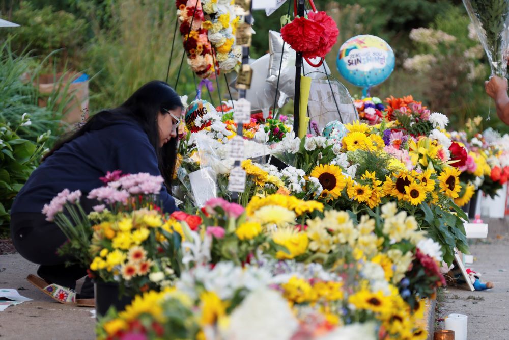 People leave flowers and keepsakes at a makeshift memorial at Annunciation Catholic Church.