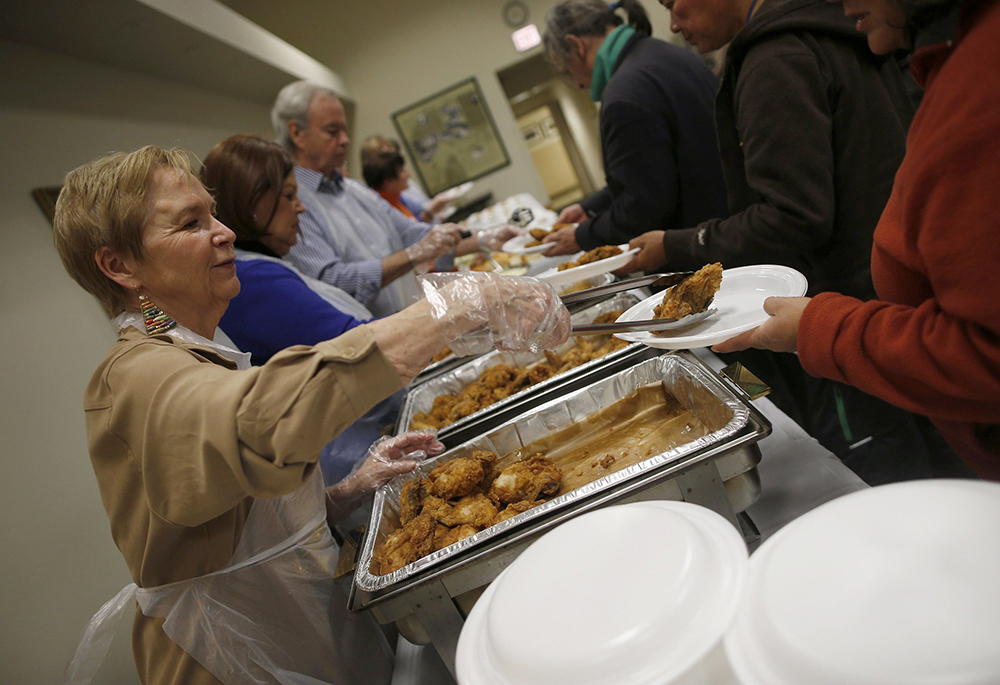 Volunteers are pictured in a file photo serving people in need during a free dinner provided by the Emergency Assistance Department of Chicago Catholic Charities. "Feeding the hungry is a fundamental work of mercy, and Christians serious about their faith would establish programs that would guarantee food to hungry people," writes Valerie Schultz. (OSV News/Reuters/Jim Young)