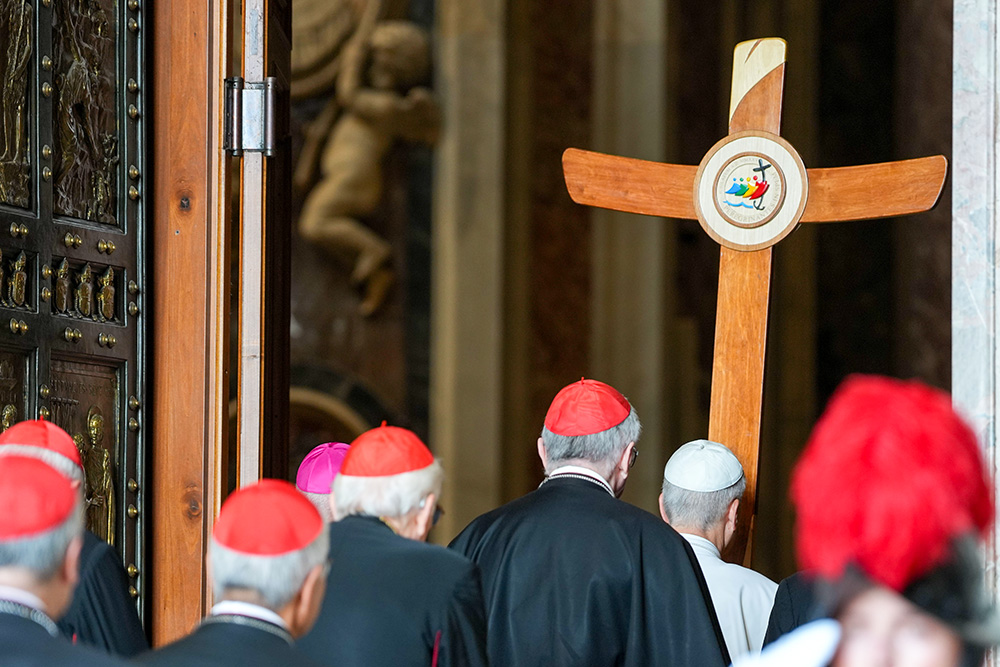 Carrying the Jubilee cross, Pope Leo XIV leads a procession of members of the Roman Curia through the Holy Door of St. Peter’s Basilica during the Jubilee of the Holy See at the Vatican June 9, 2025. (CNS/Lola Gomez)