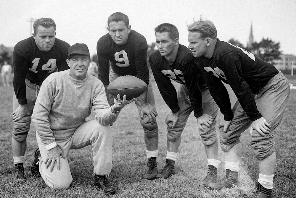 University of Notre Dame coach Frank Leahy, foreground, poses for a photo with four players at football practice on Aug. 31, 1949, in South Bend, Ind. (AP/Harry L. Hall, File)