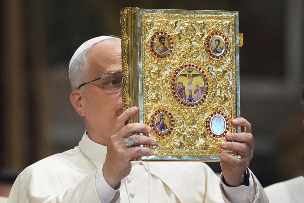 Pope Leo XIV holds the Gospel.