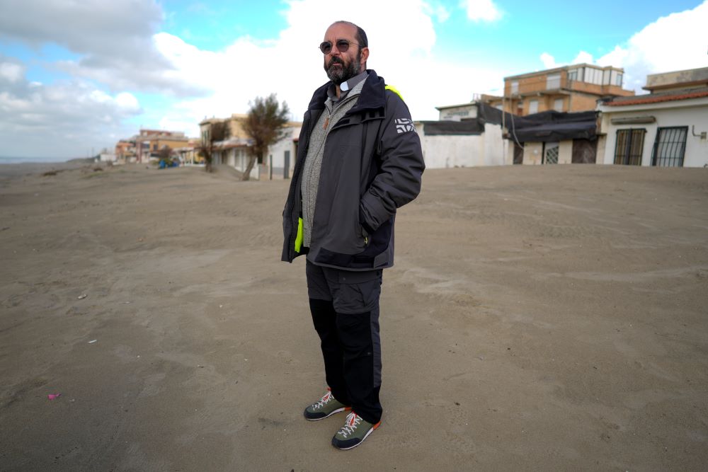 Fr. Andrea Conocchia stands on the beach of Torvaianica, Italy.