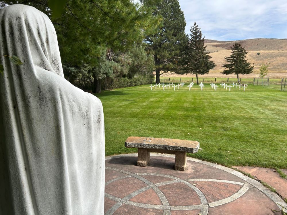 Statue of Mary overlooks cemetery.
