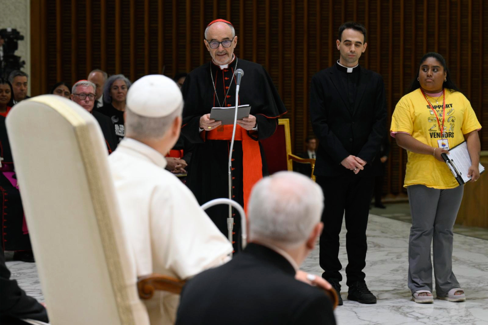 Cardinal Michael Czerny, prefect of the Dicastery for Promoting Integral Human Development, speaks to Pope Leo XIV during a gathering of popular movements as part of their Jubilee in the Paul VI Audience Hall at the Vatican Oct. 23, 2025. (CNS/Vatican Media)