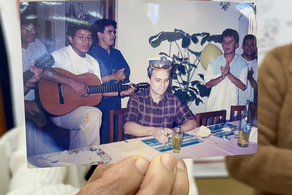 Socorro Cassaro holds up a picture of Augustinian Fr. Robert Prevost with a group of young people at Our Lady of Montserrat Parish in Trujillo, Peru. Prevost, the future Pope Leo XIV, served as parochial administrator of the parish from 1992 to 1999. (NCR photo/Justin McLellan)
