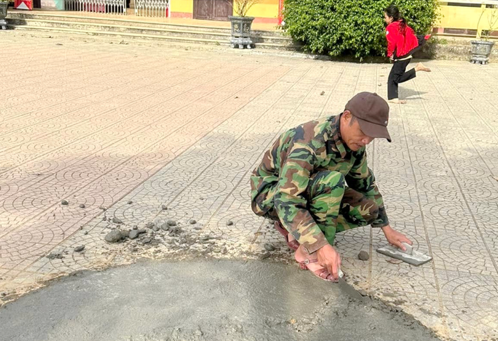 A soldier applies cement over the surface of a playground at a school in Cam Lo, Quang Tri province, just one week after an unexploded shell was safely removed from the site. (NCR photo)