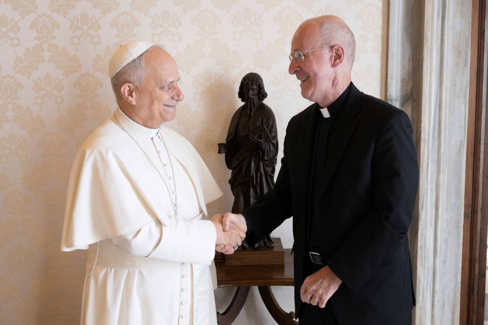 Pope Leo XIV welcomes Jesuit Fr. James Martin, an author and editor at large at America magazine, to the library of the Apostolic Palace at the Vatican.