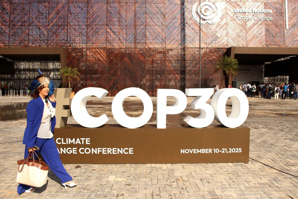 Woman walks near sign for COP#).