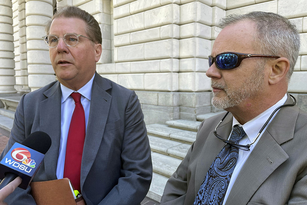 Lawyer Paul Sterbcow, left, with his client, attorney Richard Trahant, talks to reporters outside the federal appeals court building in New Orleans April 3, 2024. Trahant is appealing a $400,000 court sanction for allegedly violating a bankruptcy court secrecy order by alerting a school principal and a reporter that a suspected child predator was working as a chaplain at a high school. (AP/Kevin McGill)