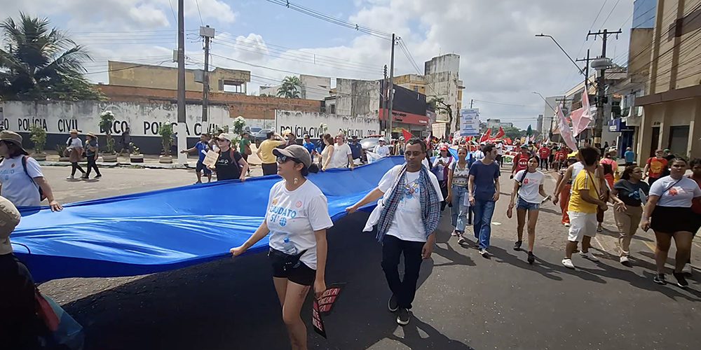 Catholics with the Laudato Si' Movement carry the "River of Hope" banner through the streets of Belém, Brazil, at the global climate march Nov. 15 during the COP30 United Nations climate change conference. (Eduardo Campos Lima)