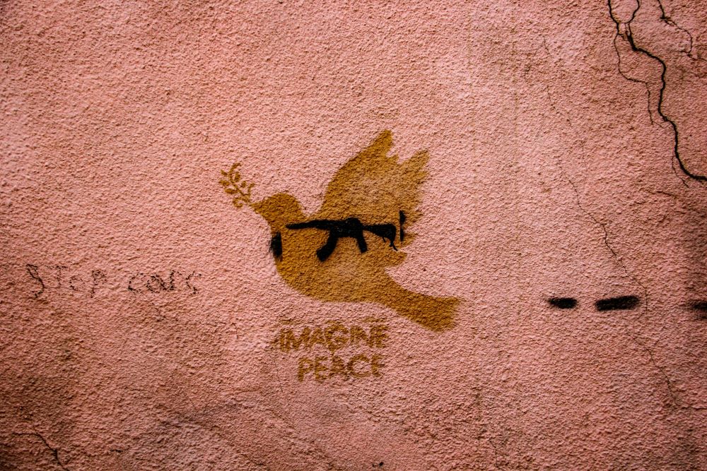 Drawing of peace dove on wall, with phrase, "imagine peace"