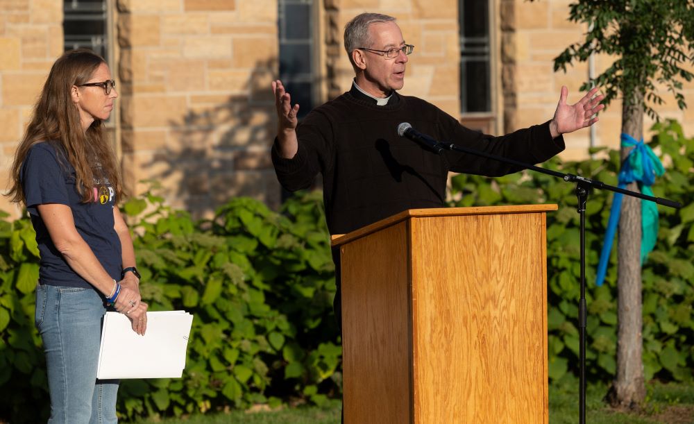 Fr. Dennis Zehren raises his hands in prayer.