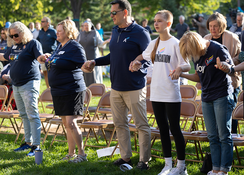 Harry Kaiser, center, prays the Our Father with his daughter, Lydia, second from right, and wife, Leah, right, during a prayer service at Annunciation in Minneapolis on Sept. 27, 2025, the one-month anniversary of a shooting at the church. Lydia is a student at Annunciation Catholic School and was among those injured in the shooting. NCR spoke to other Annunciation parents about their experience in the shooting's aftermath. (OSV News/The Catholic Spirit/David Hrbacek)