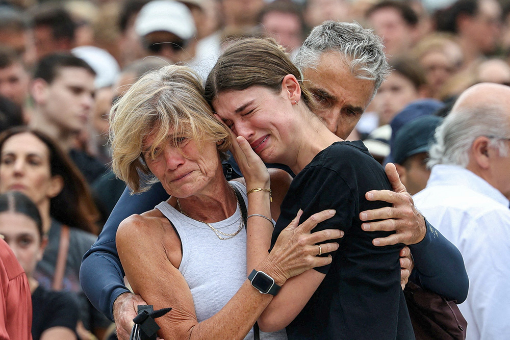 A woman cries as she pays her respects at Bondi Pavilion Dec. 15, 2025, to victims of a shooting during a Jewish holiday celebration at the beach in Sydney. Two gunmen opened fire during a Hanukkah celebration on Sydney’s Bondi beach Dec. 14, killing 15 people, including a child, officials said. (OSV News/Reuters/Hollie Adams)