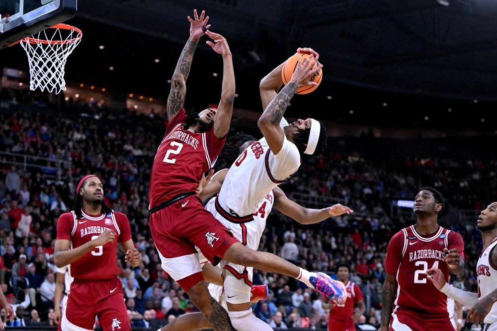 Arkansas Razorbacks guard Boogie Fland (2) and St. John's Red Storm guard Aaron Scott (0) fight for a rebound during the second half of a second round men's NCAA Tournament game at Amica Mutual Pavilion in Providence, R.I., March 22, 2025. 