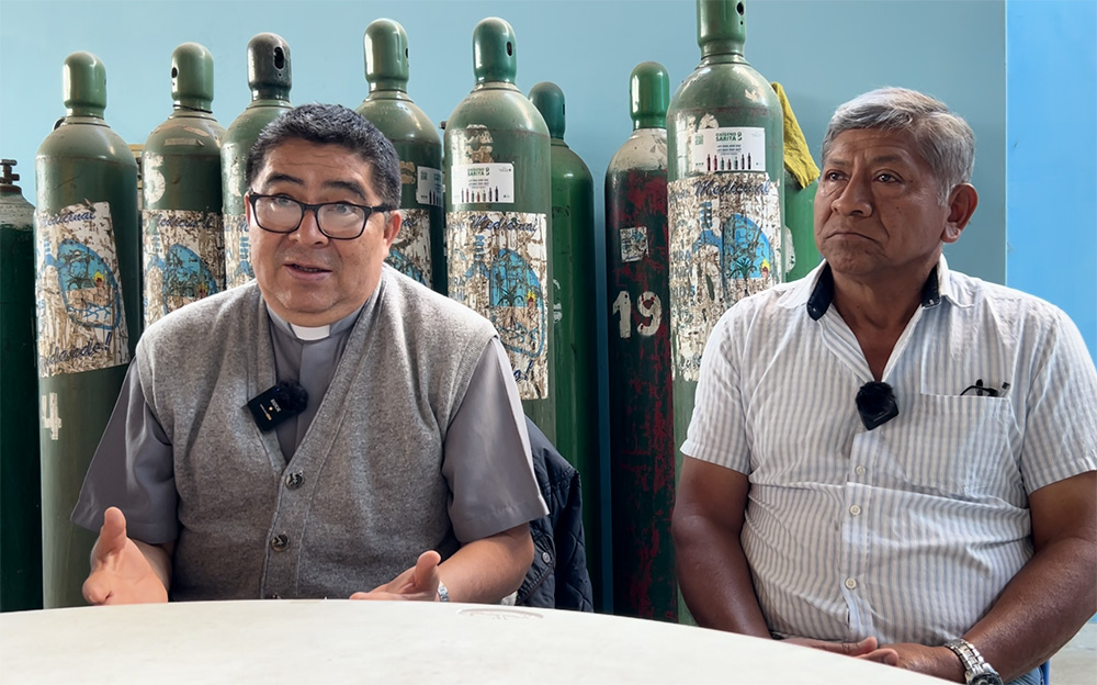Fr. Orestes Milián Flores, left, and Jorge Musayón speak during an interview with NCR at the oxygen plant built with the support of Bishop Robert Prevost in Mochumí, Peru, Aug. 7, 2025. (NCR photo/Justin McLellan)
