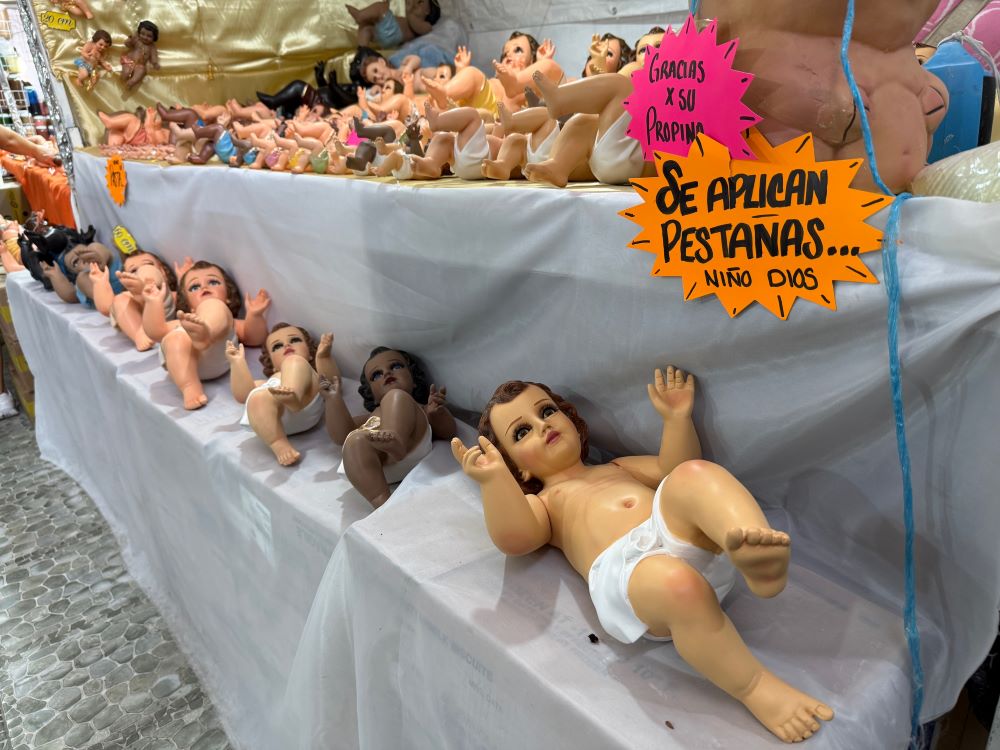 Baby Jesus figurines are displayed for sale at a Mexico City market Jan. 27, 2026 in the days leading up to Candlemas, celebrated Feb. 2. The signs read: "Thank you for your tip" and "Eyelashes applied, Baby Jesus." (Anita Snow)