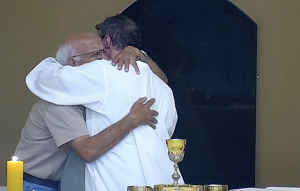 Fr. Carlos Henrique Fernandes of the Diocese of Tubarão, Brazil, right, embraces a crying elderly man named Marcos who approached the altar moments before Communion at the Church of St. Francis of Assisi in Tubarão Jan. 18, 2026. (OSV News/Communications Pastoral Ministry via YouTube)