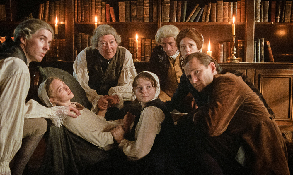 From left: Matthew Beard, Amanda Seyfried, Scott Handy, Thomasin McKenzie, Jeremy Wheeler, Stacy Martin and Lewis Pullman appear in "The Testament of Ann Lee." (Courtesy of Searchlight Pictures)