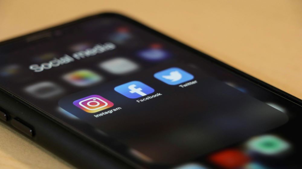 cell phone screen shows social media icons.