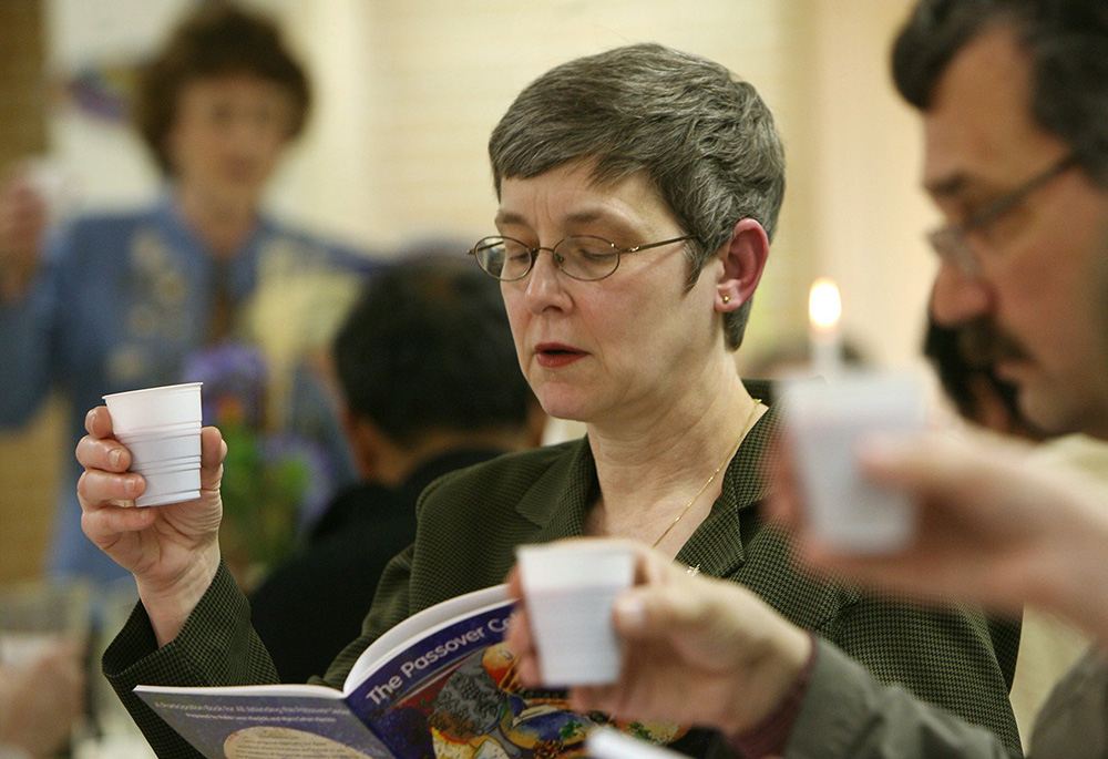 In this 2007 photo, Sandra Steele lifts a cup of grape juice, symbolizing wine, during a Seder meal at St. Thomas More Church in Munster, Indiana, March 24. The Seder is a special ritual during the Jewish festival of Passover, a holiday commemorating Jewish deliverance from Egyptian bondage and the time of the barley season. Many Catholics participate in a Seder during the season of Lent. (CNS/Northwest Indiana Catholic/Karen Callaway) 
