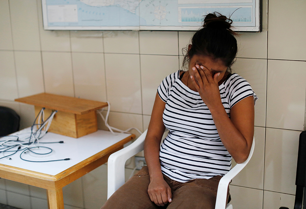 A Honduran woman holds back tears while waiting in a migrant shelter in Guatemala City, Guatemala, July 15, 2019. (CNS/Reuters/Luis Echeverria)