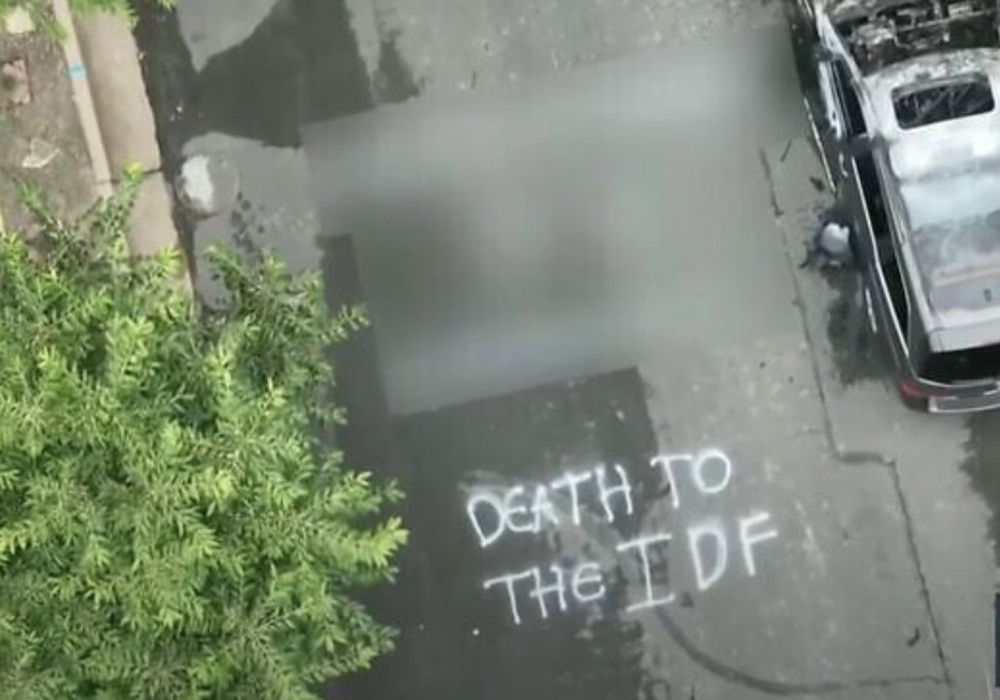 This screenshot of aerial footage from KMOV 4 News shows graffiti reading "Death to the IDF" and a burnt car on a street in Clayton, Missouri, Aug. 6, 2025. In a statement released Aug. 7, 2025, St. Louis Archbishop Mitchell T. Rozanski said, "Antisemitism and hatred have no place in our community," following an attack in front of an Israel Defense Forces soldier's home in Clayton. (OSV News screenshot/YouTube)