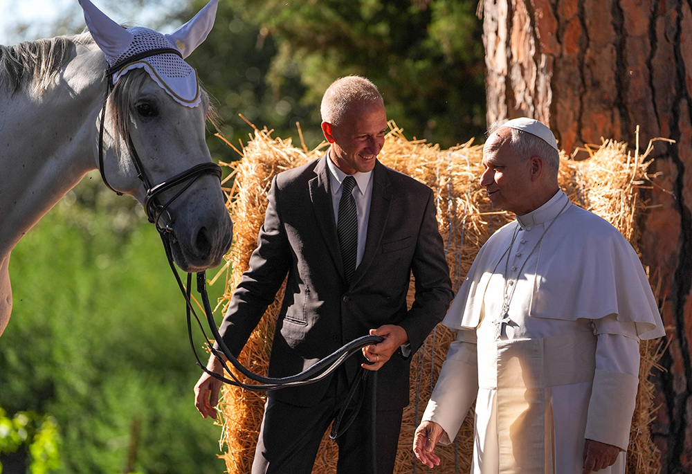Pope Leo XIV looks at a horse as he greets an employee of the papal gardens in Castel Gandolfo, Italy, Sept. 5, 2025. The pope inaugurated Borgo Laudato Si' the same day, officially opening the historic papal residence as a center dedicated to the principles of care for creation and human dignity outlined in Pope Francis' encyclical Laudato Si'. (CNS/Lola Gomez)