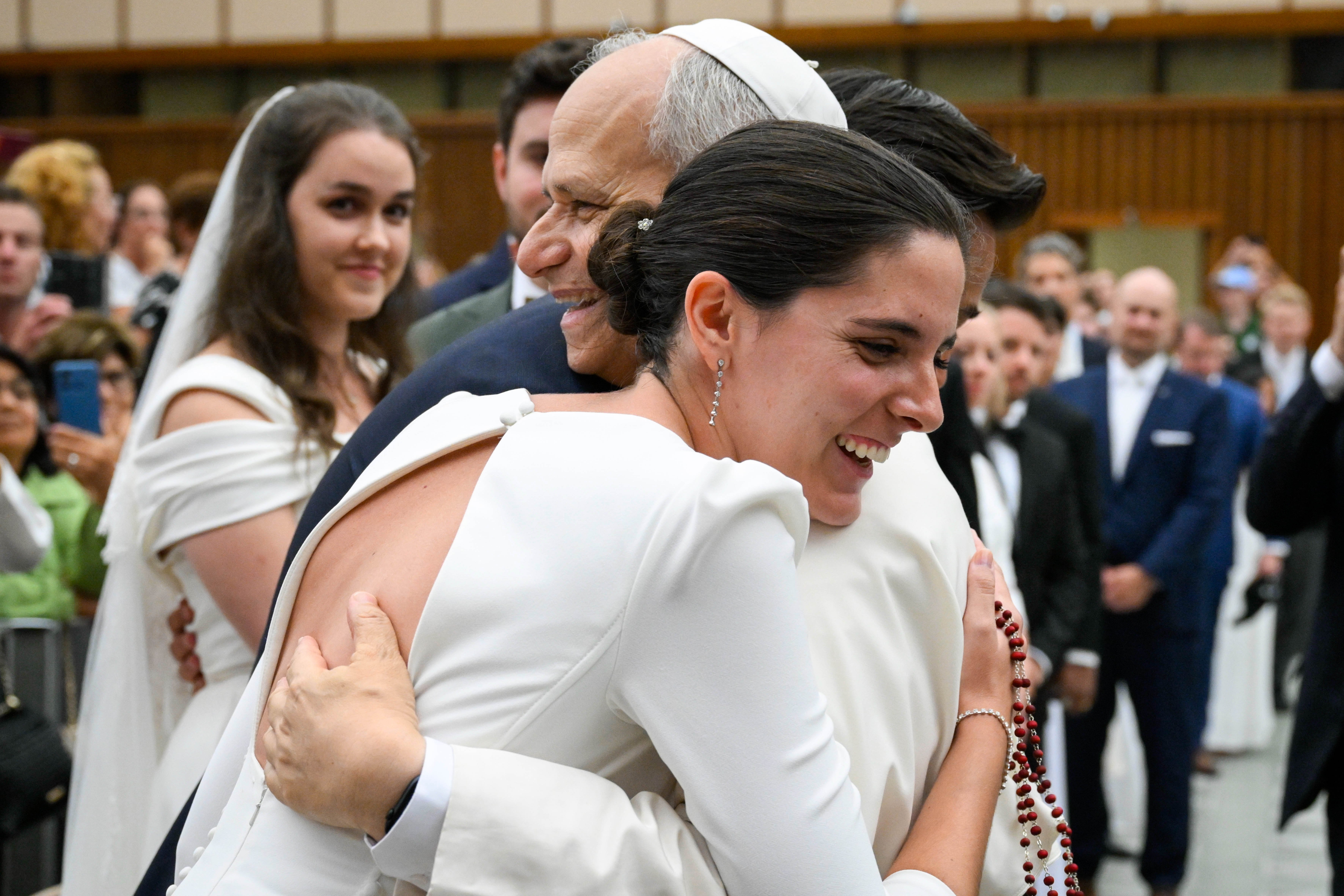 Pope Leo XIV embraces a newly married couple at the conclusion of his weekly general audience in the Paul VI Audience Hall at the Vatican Aug. 27, 2025. Leo announced March 19, 2026, that he is asking the presidents of all bishops' conferences around the world to convene in Rome in October to renew and deepen the Church's discussion on marriage and family in light of Amoris Laetitia. (CNS/Vatican Media)
