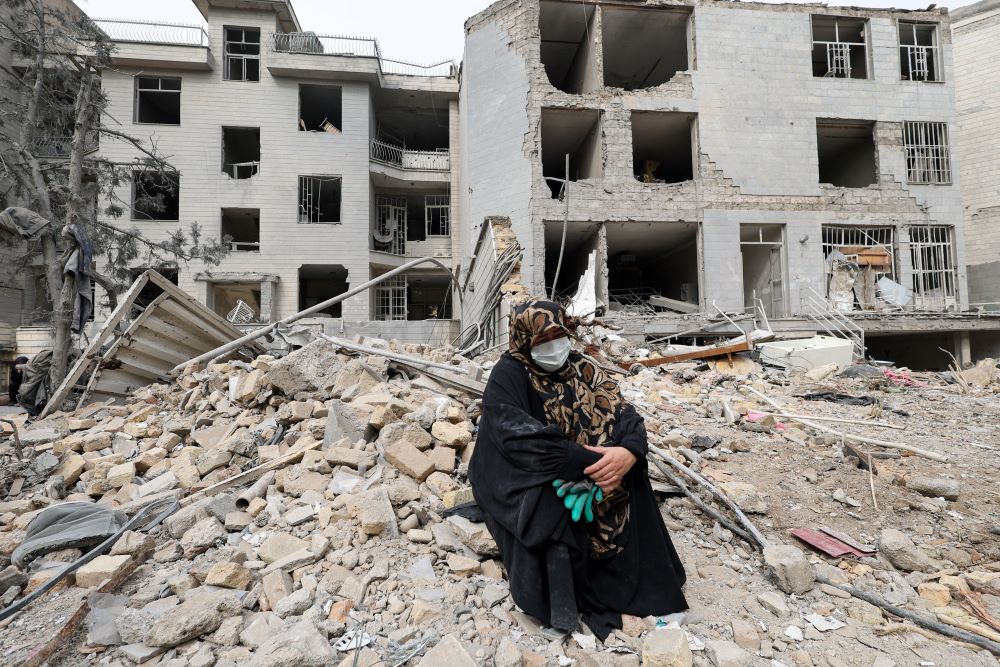 A woman sits amid rubble outside her destroyed apartment in Tehran, Iran, March 12, following an airstrike amid the U.S.-Israeli war with Iran. (OSV News/Reuters/Alaa Al Marjani)